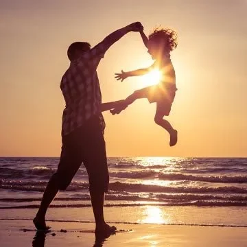 Father and Daughter At The Beach During Sunset